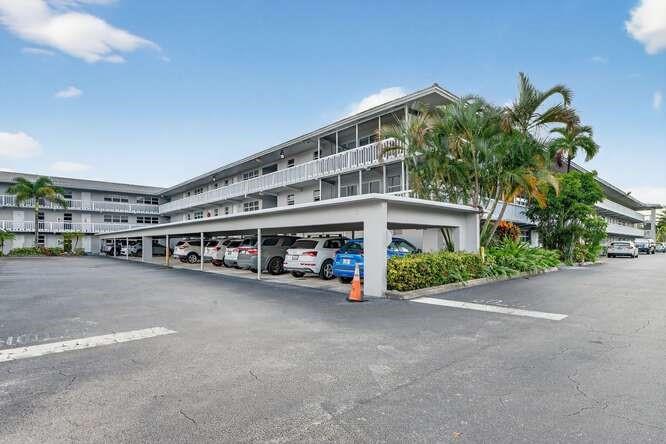 1200 Southwest 12th Court, Unit 203 Fort Lauderdale, FL 33315 - Photo 22 of 23 a big building with plants and a car parked in it
