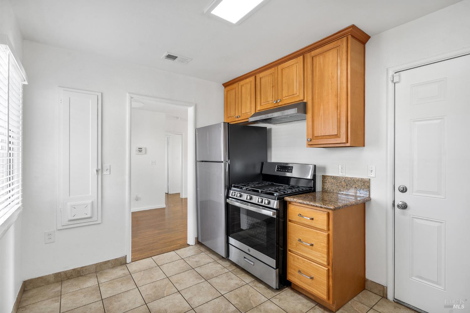 458 Spring Street Richmond, CA 94804 - Photo 11 of 26 a kitchen with stainless steel appliances granite countertop a stove a sink and a refrigerator