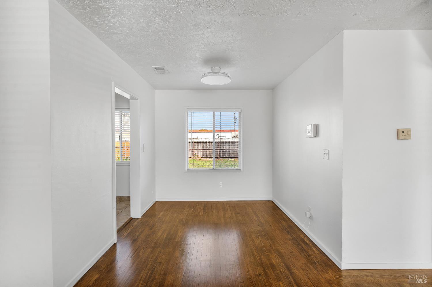 458 Spring Street Richmond, CA 94804 - Photo 8 of 26 an empty room with wooden floor and windows