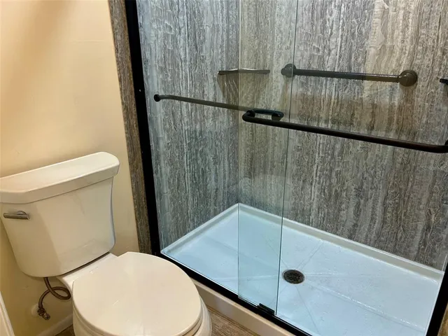 a bathroom with a toilet and a shower