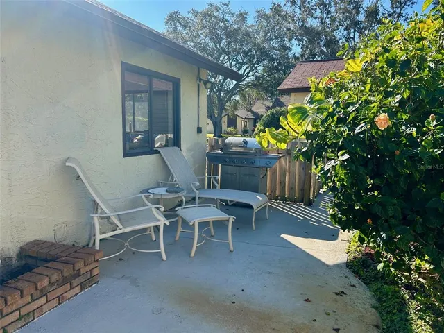 a patio with table and chairs and potted plants