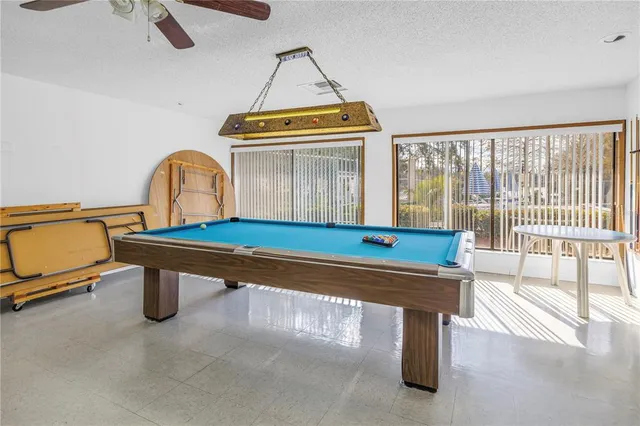 a room with pool table and windows
