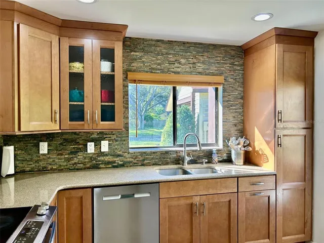a kitchen with stainless steel appliances granite countertop a sink and a window