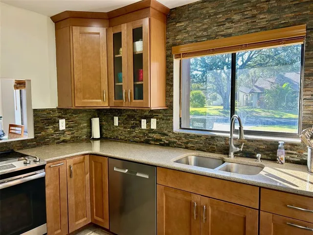 a kitchen with sink a window and cabinets