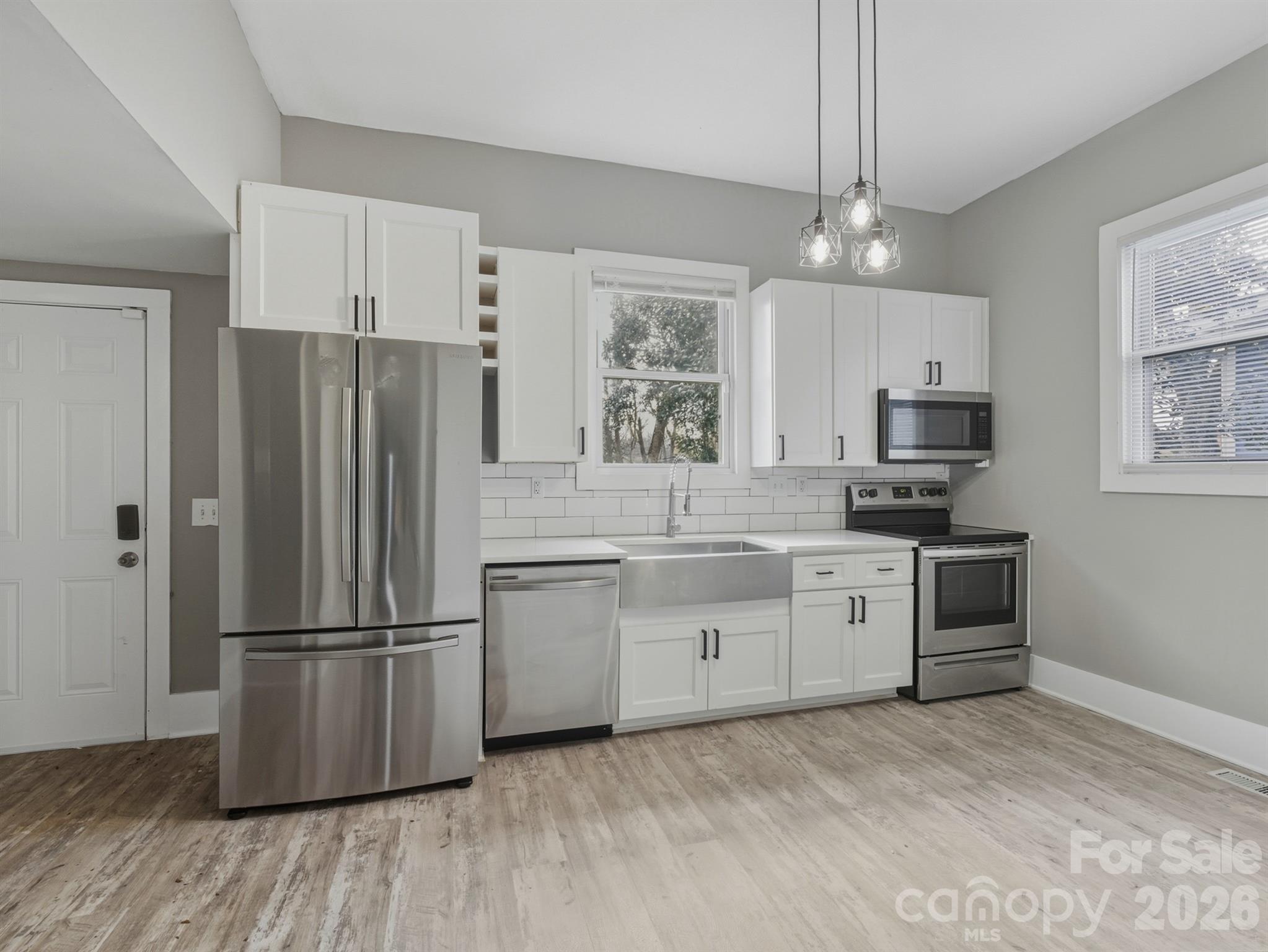 4313 Hovis Road Charlotte, NC 28208 - Photo 4 of 24 a kitchen with granite countertop stainless steel appliances a refrigerator cabinets and wooden floor