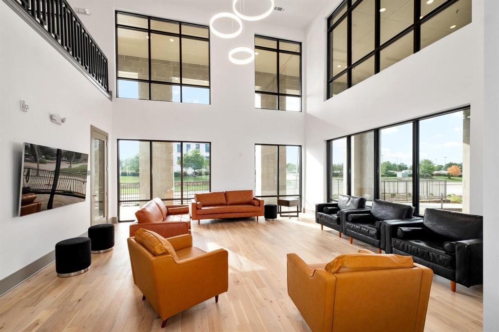 2700 Old Denton Road, Unit 3359 Carrollton, TX 75007 - Photo 1 of 32 Living area with wood finished floors, a towering ceiling, and a wealth of natural light