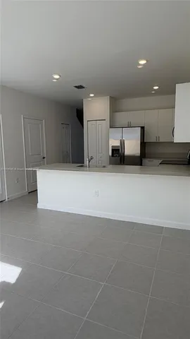 a view of a kitchen with a sink and a refrigerator