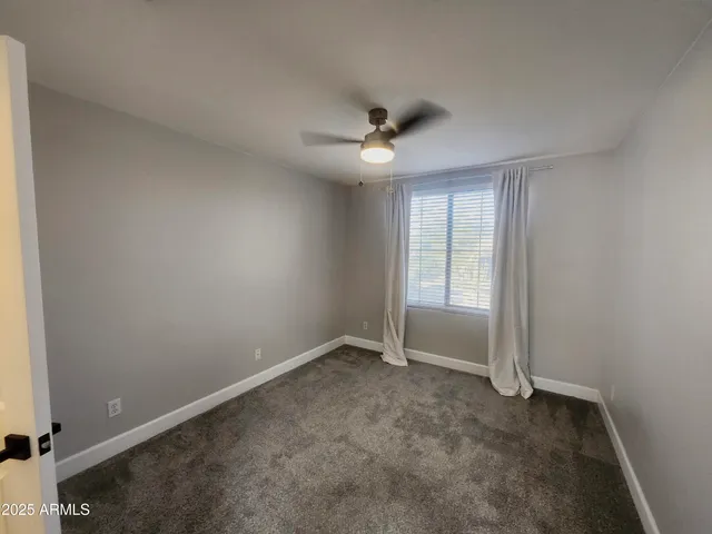an empty room with closet and a chandelier fan