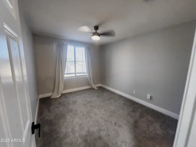 an empty room with closet and a chandelier fan