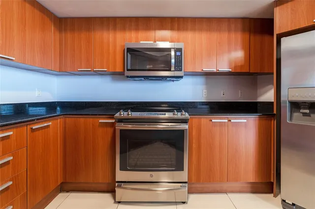 a kitchen with stainless steel appliances granite countertop a refrigerator and a sink