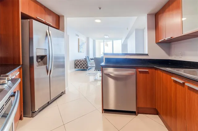 a kitchen with stainless steel appliances granite countertop a refrigerator and a stove