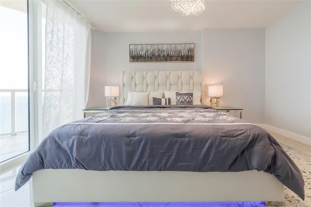 a white bed sitting in a room next to a window