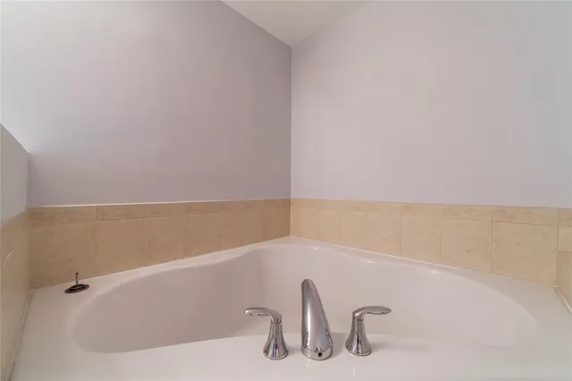 a view of an empty room with mirror and door