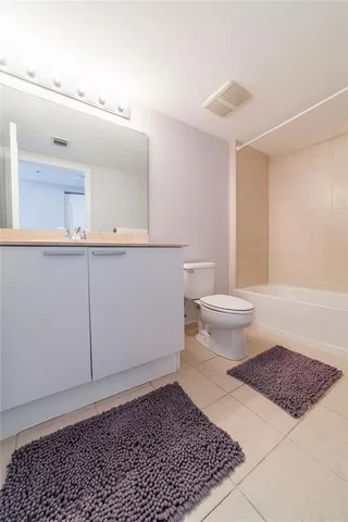 a living room with furniture a flat screen tv and kitchen view