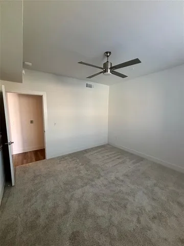 a view of a room with a ceiling fan and a window