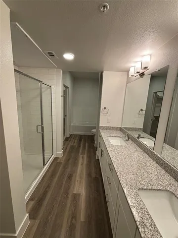 a bathroom with a granite countertop sink a mirror and shower