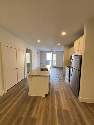 a view of kitchen with sink and refrigerator