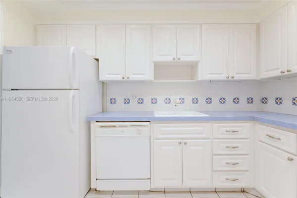 a kitchen with white cabinets stainless steel appliances and sink