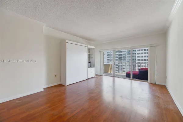 a view of empty room with wooden floor and fireplace