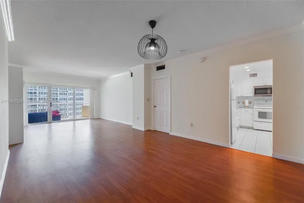 a view of empty room with wooden floor and window