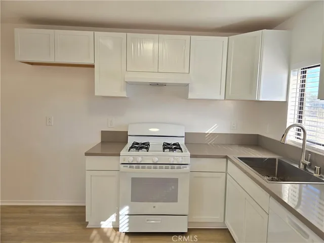 a kitchen with a sink stove and cabinets