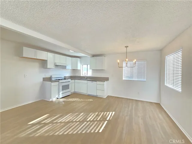 a kitchen with stainless steel appliances granite countertop a sink cabinets and wooden floor