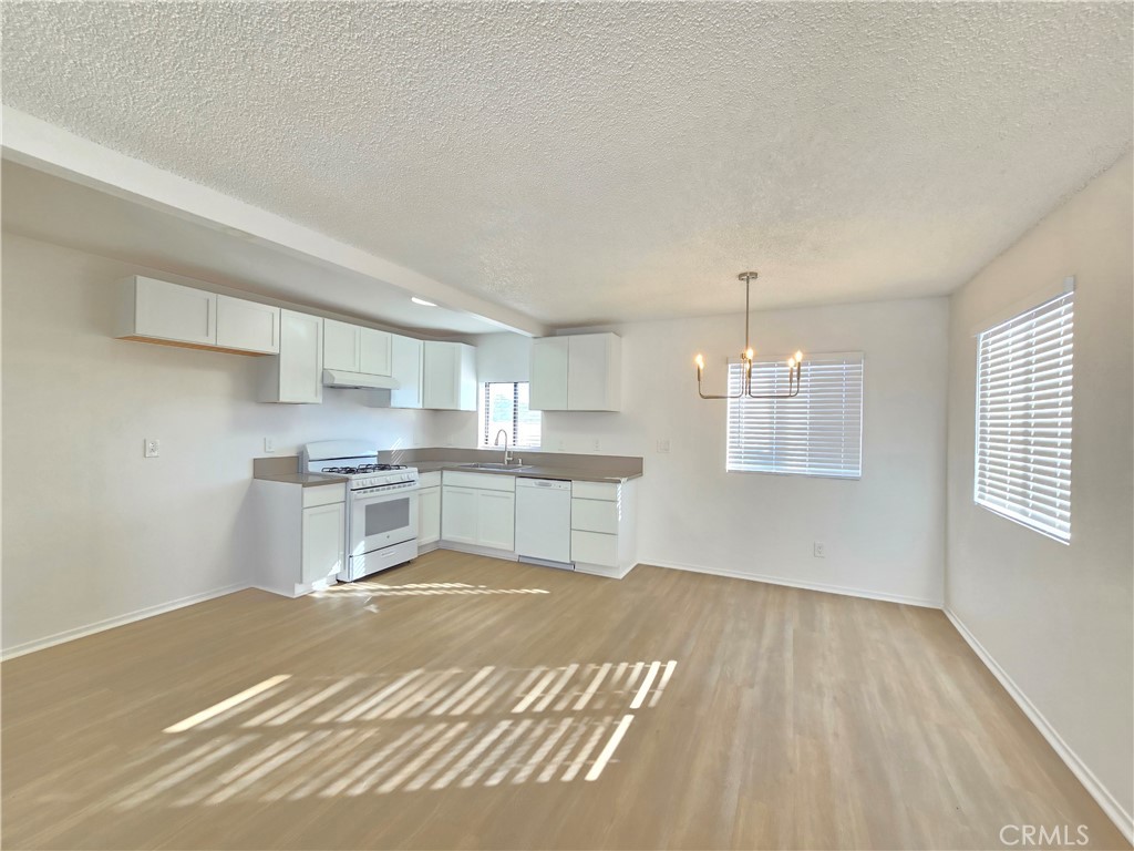 8249 Catalpa Avenue, Unit A California City, CA 93505 - Photo 5 of 12 a kitchen with stainless steel appliances granite countertop a sink cabinets and wooden floor