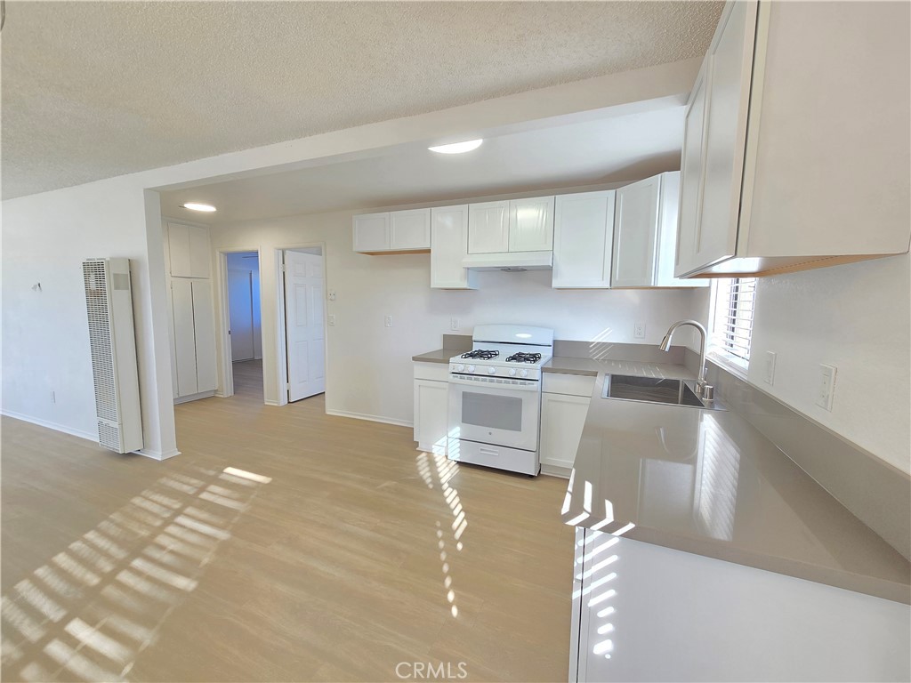 8249 Catalpa Avenue, Unit A California City, CA 93505 - Photo 6 of 12 a kitchen with white cabinets and stainless steel appliances