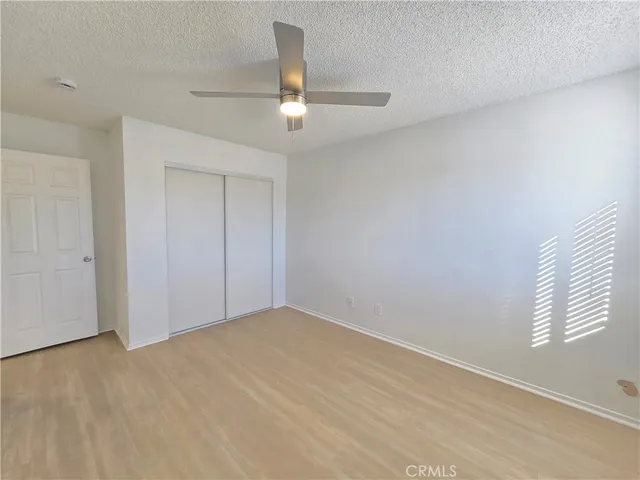 an empty room with windows and fan