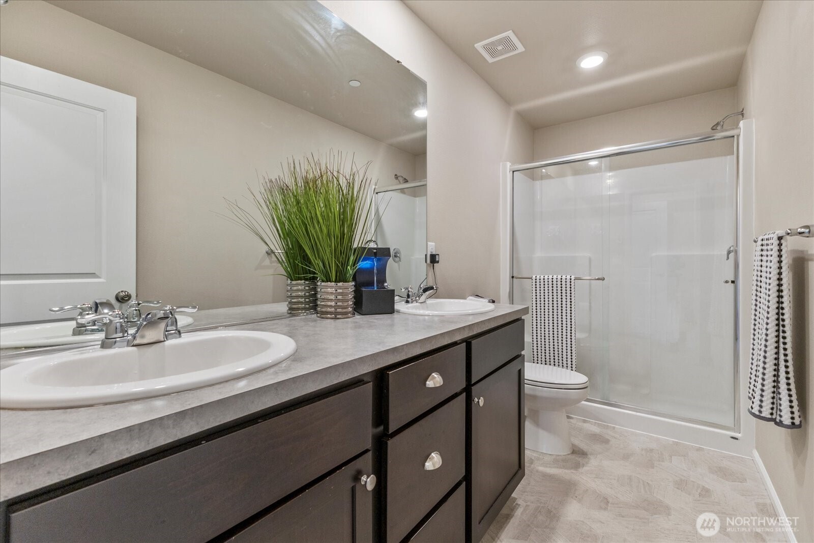17401 118th Ave Court East, Unit A Puyallup, WA 98374 - Photo 16 of 25 a bathroom with a granite countertop sink a toilet a mirror and shower
