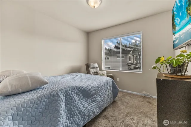 a bedroom with a bed table and a window