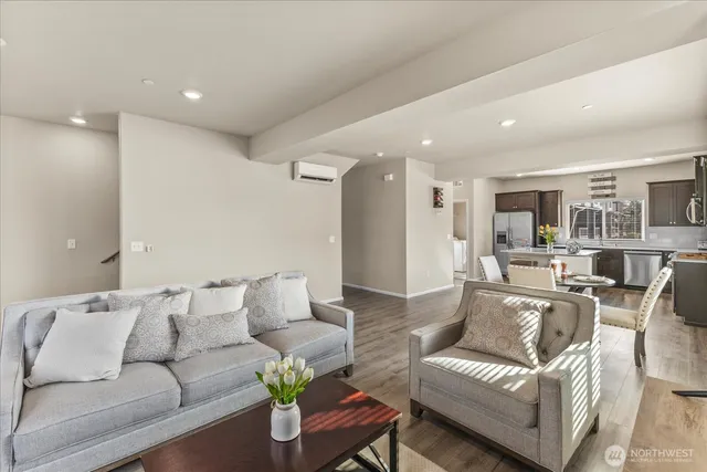 a living room with furniture and a view of kitchen