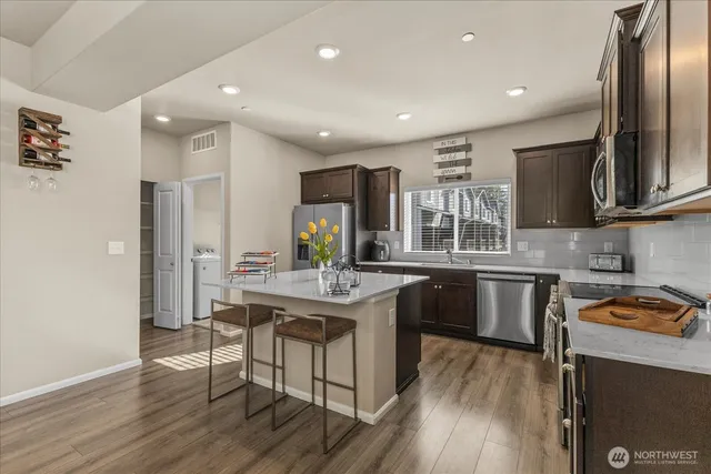 a kitchen with granite countertop cabinets stainless steel appliances and a center island