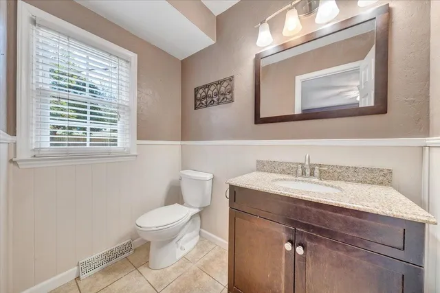 a bathroom with a toilet a sink and mirror