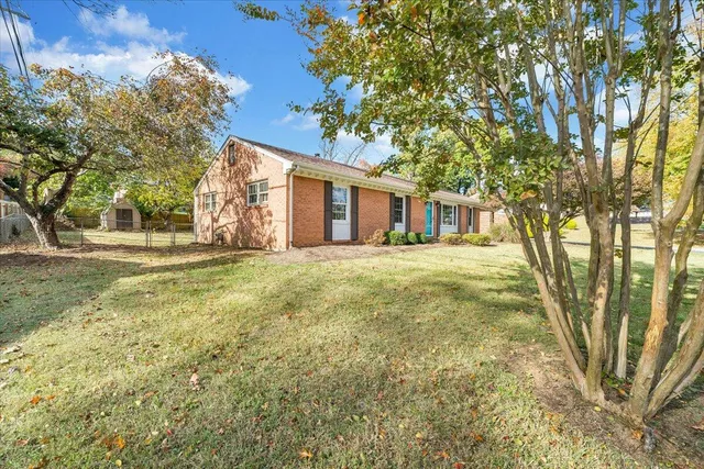 a big yard with trees in front of it