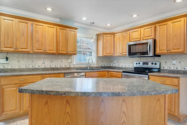 a kitchen with granite countertop a stove top oven a sink a counter space and cabinets