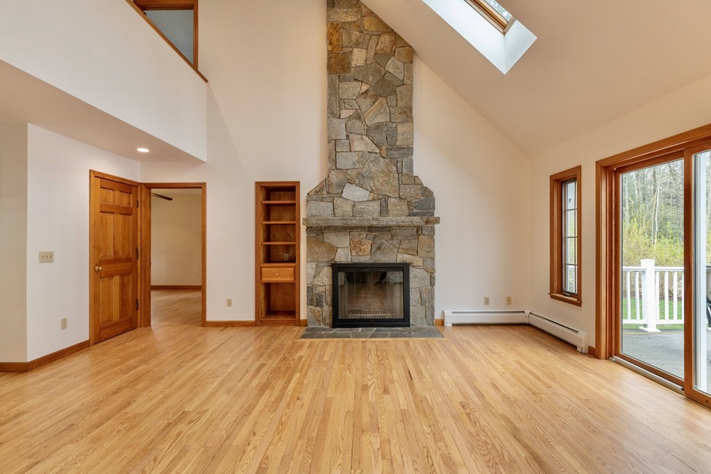 91 Main Road Westhampton, MA 01027 - Photo 13 of 35 an empty room with wooden floor fireplace and windows