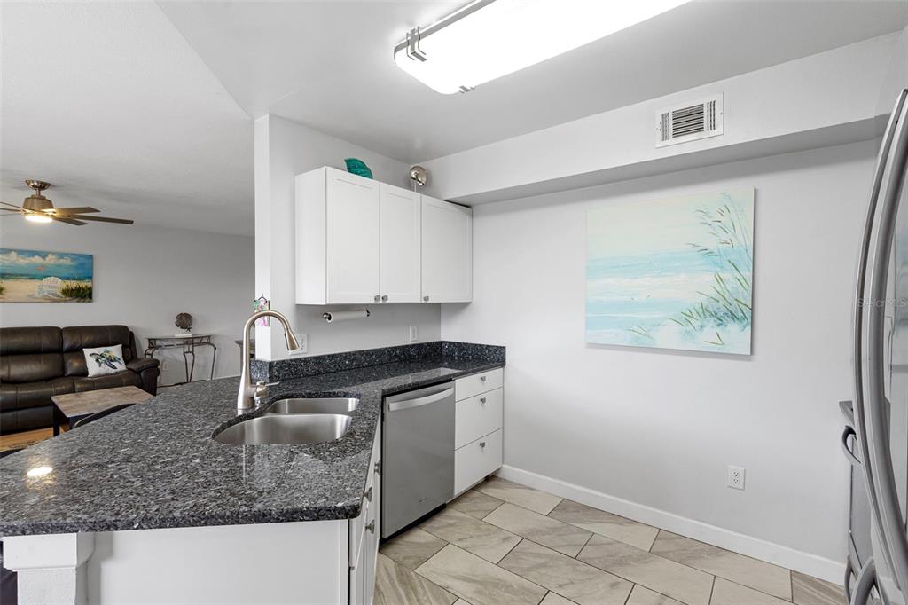 7470 Highway 1, Unit 105 Cocoa, FL 32927 - Photo 14 of 37 a kitchen with stainless steel appliances granite countertop a sink stove and cabinets