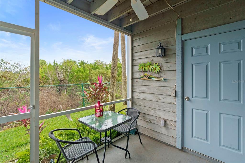 7470 Highway 1, Unit 105 Cocoa, FL 32927 - Photo 28 of 37 a balcony with table and chairs and wooden floor