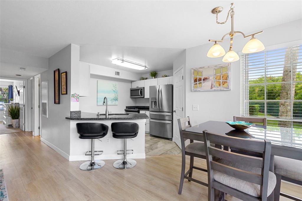 7470 Highway 1, Unit 105 Cocoa, FL 32927 - Photo 10 of 37 a dining room with wooden floor and chandelier