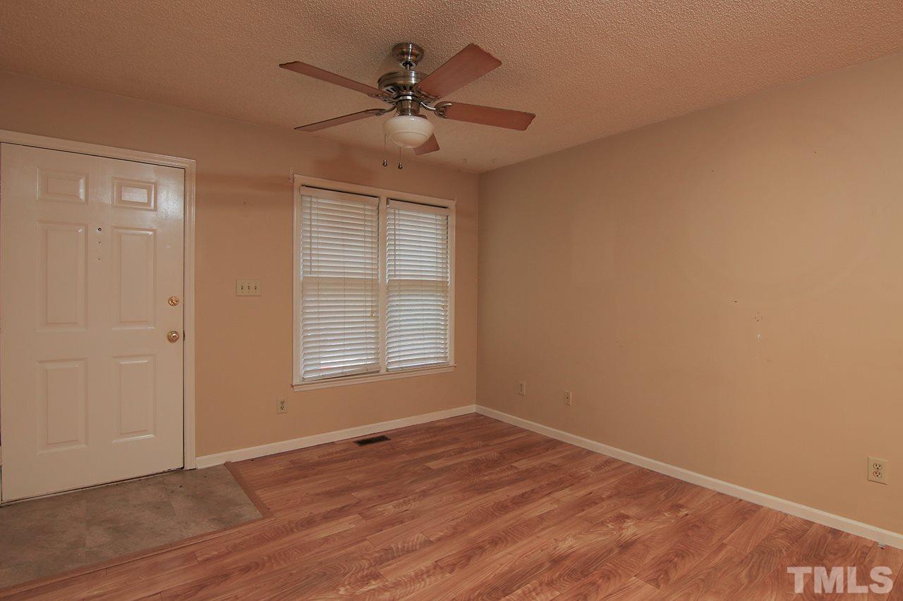 2305 Merganzer Road Raleigh, NC 27616 - Photo 2 of 10 an empty room with wooden floor fan and windows