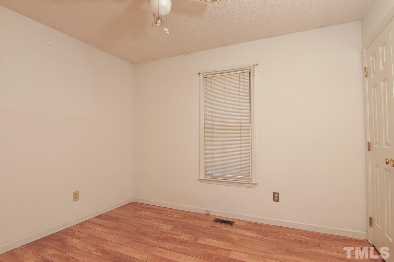 2305 Merganzer Road Raleigh, NC 27616 - Photo 7 of 10 an empty room with wooden floor cabinet and windows