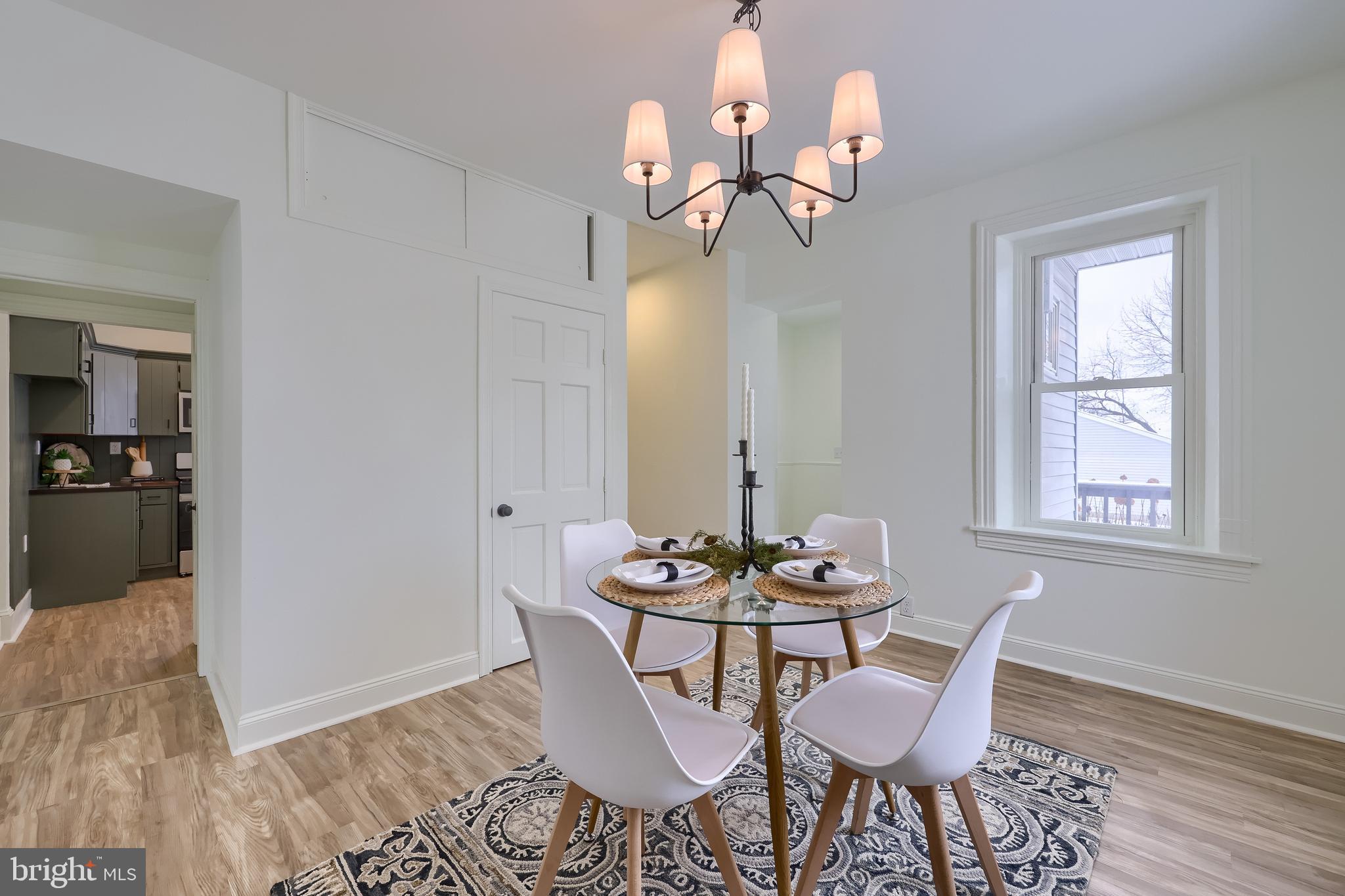 645 South Main Street Red Lion, PA 17356 - Photo 12 of 53 a dining room with wooden floor a chandelier a glass table and chairs