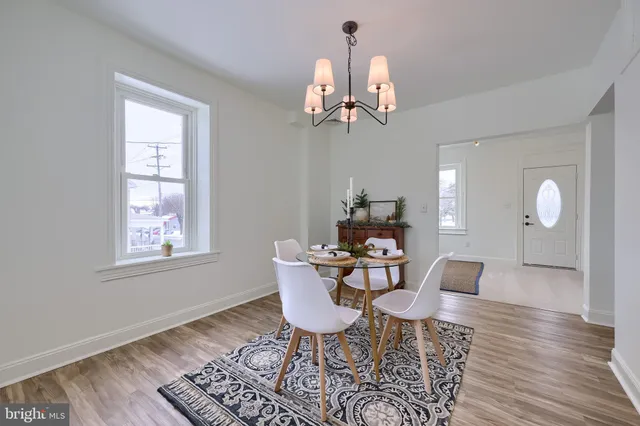 a view of a dining room with furniture a chandelier and wooden floor