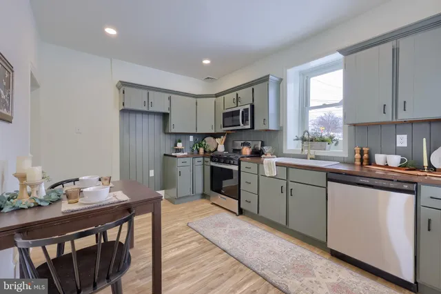 a kitchen with granite countertop a sink counter space cabinets and stainless steel appliances
