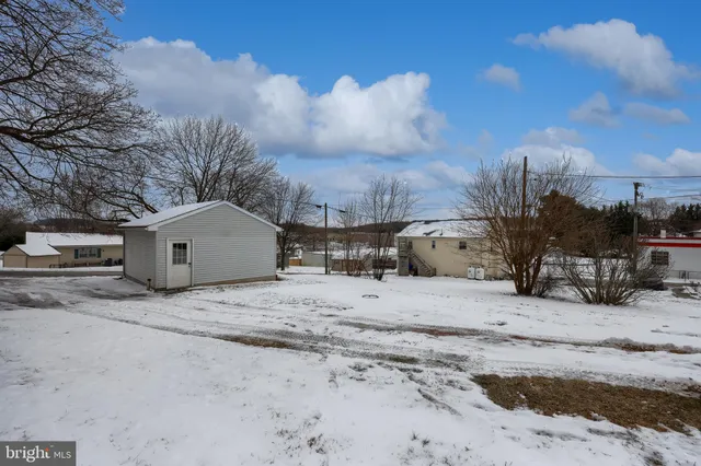 a view of large house with a yard covered in snow