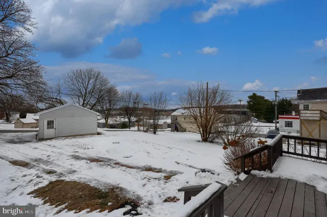 a view of a roof deck with couches and wooden fence