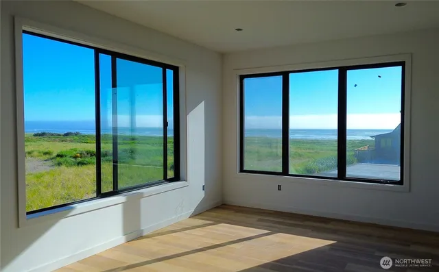 a view of a bedroom with wooden floor and white walls