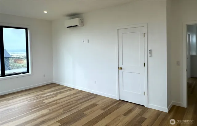 a view of empty room with wooden floor