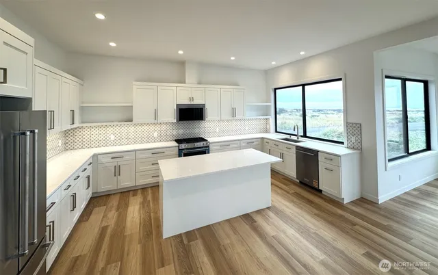 a kitchen with granite countertop white cabinets and white appliances